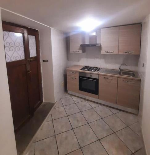 a kitchen with a stove and a sink and a door at Il rifugio dell'escursionista in Casperia