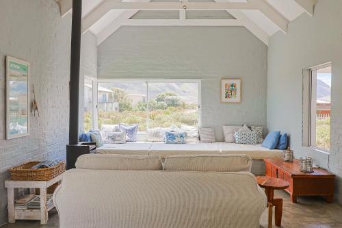Dos camas en una habitación con una gran ventana. en Lily House, en Bettyʼs Bay