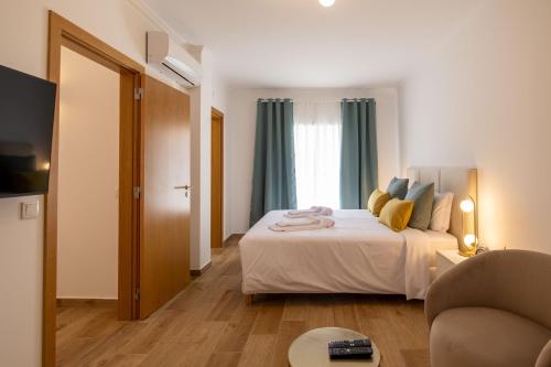 a hotel room with a bed and a couch at Luxuosa Villa com Piscina, Garagem e Vista Mar in Tavira