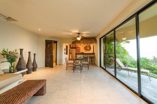 an open living room with glass doors and a table at 2010 - Villa Allure in Valerio Martínez