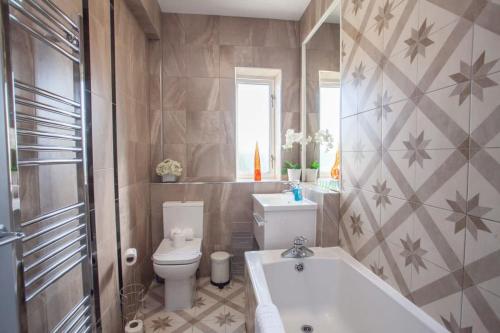 un bagno con wc e vasca da bagno di Beautifully Designed Pollok House a Glasgow