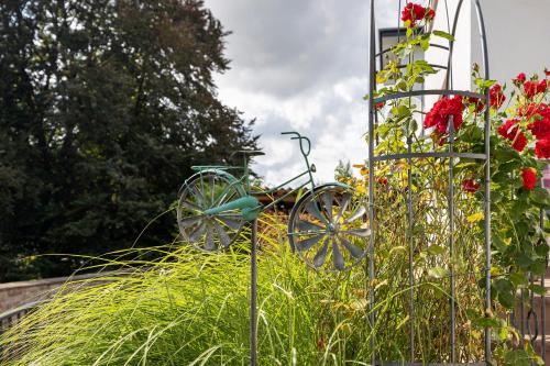a bicycle in a garden next to some flowers at Ferienwohnung Landradler in Bad Karlshafen