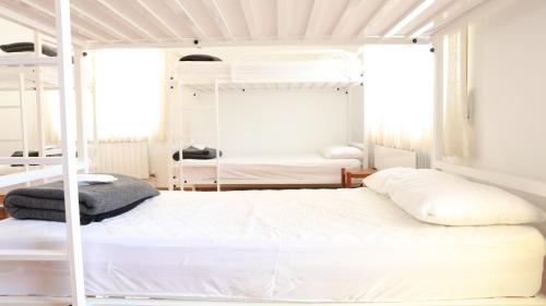 a bedroom with two bunk beds with white walls at Pensión Albergue Gonzar in Portomarin