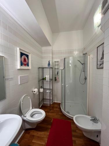 a bathroom with a toilet and a sink and a shower at Art District Loft Venice in Venice