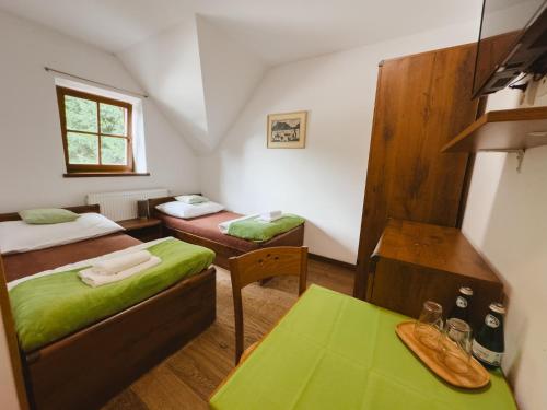 a small room with two beds and a table at Majláthova Chata Popradské Pleso in Vysoké Tatry