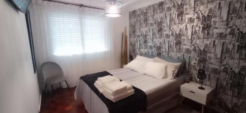 a bedroom with a bed with a black and white wall at As Mariñas 92 in Boiro