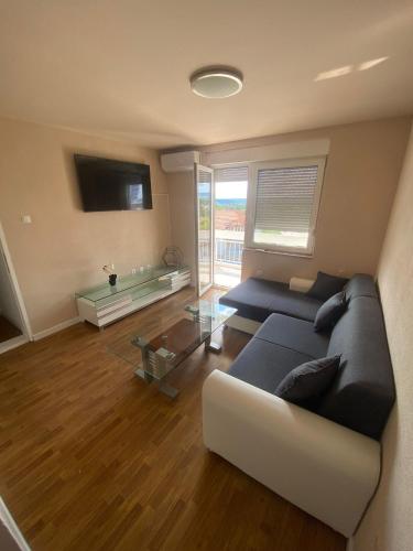 a living room with a couch and a glass table at Apartman BM2 in Posušje