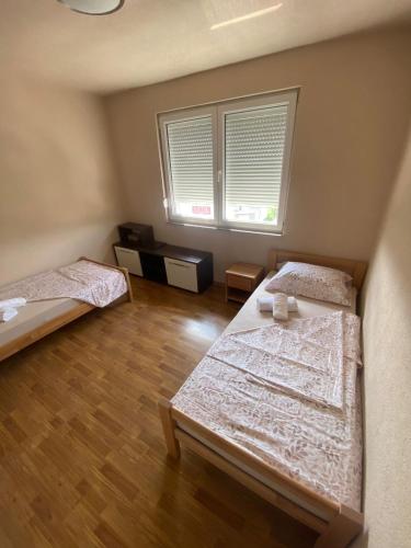 a bedroom with two beds and a window at Apartman BM2 in Posušje