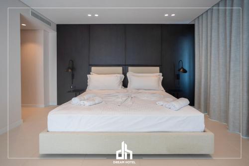 a bedroom with a large white bed with towels on it at DREAM HOTEL SARANDA in Sarandë