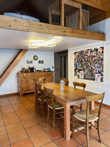 une salle à manger avec une table et des chaises en bois dans l'établissement Le chalet sur le toit, à Briançon