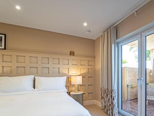 a bedroom with a large bed and a window at Farmyard House in Amlwch