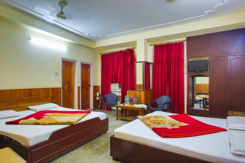 贾姆穆Hotel Raghunath的酒店客房,配有两张带红色窗帘的床