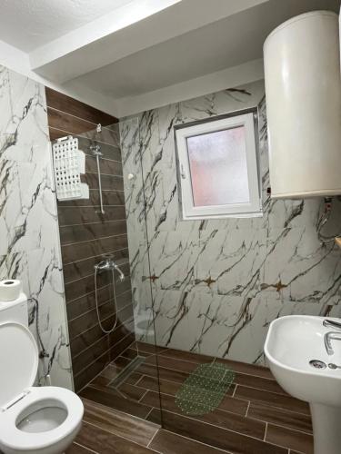 Un baño con ducha, inodoro y lavabo. en Lotos Apartments, en Struga