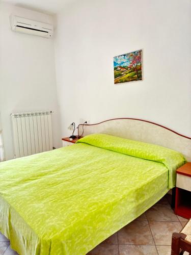 a bedroom with a bed with a green blanket on it at Casa Josefina in Sant'Angelo D'Ischia
