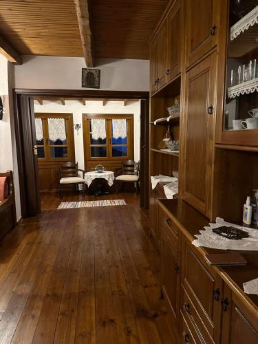 a large kitchen with wooden floors and wooden cabinets at Το Ανώι in Palaios Panteleimonas