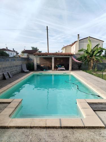 une grande piscine bleue dans une cour dans l'établissement Location chambre spacieuse avec balcon et piscine, à Albi