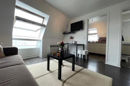 un salon avec un canapé et une table dans l'établissement T1 comfort with nice open view, à Trouville-sur-Mer