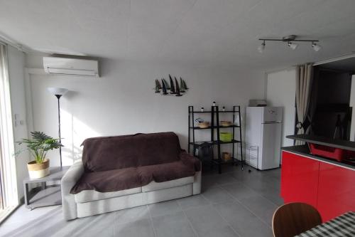 - un salon avec un canapé et un réfrigérateur dans l'établissement A balcony overlooking the marina, à Frontignan