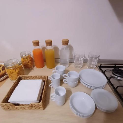 a table with white plates and cups and bottles at Casale Trifoglio in Morano Calabro