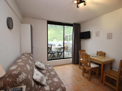- un salon avec un canapé et une table à manger dans l'établissement Mont-Dore Studio 2* avec garage, 300m du centre - FR-1-608-148, à Le Mont-Dore