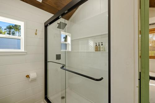 a shower with a glass door in a bathroom at Vista Verde Farm Retreat - Stylish Cabins Nearby Springs in Ellisville