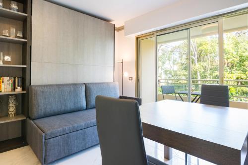 une salle à manger avec une table et un canapé dans l'établissement Isola Bella by Connexion, à Cannes