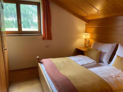 a bedroom with a bed and a window in a room at Haus Karin Mallnitz in Mallnitz