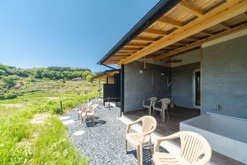 a house on a hill with chairs and a tub at THE TANADA SAUNA サウナ 露天風呂 棚田一望 Refaシャワードライヤー in Sakai