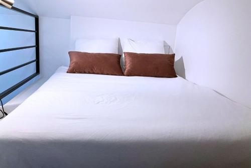 un lit blanc avec deux oreillers dessus dans l'établissement The 