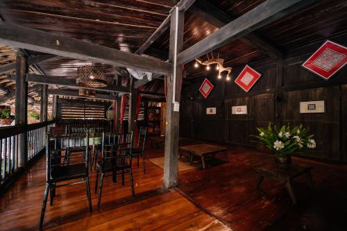 a dining room with tables and chairs in a building at Ha Giang Xanh Retreat - Trekking, Tour, Motorbike Rental in Ha Giang