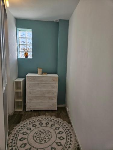 Cette chambre comprend une commode, une fenêtre et un tapis. dans l'établissement Studio cozy proche Versailles, à Toussus-le-Noble