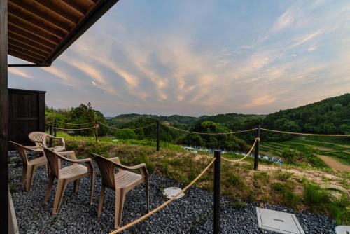 a group of chairs sitting on a patio with a view at THE TANADA SAUNA サウナ 露天風呂 棚田一望 Refaシャワードライヤー in Sakai