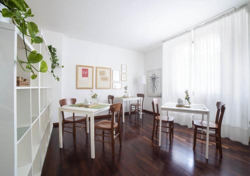 a dining room with white tables and chairs at la foglia verde in Pesaro