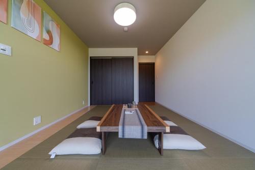 a room with a table with pillows on the floor at THE TANADA SAUNA サウナ 露天風呂 棚田一望 Refaシャワードライヤー in Sakai
