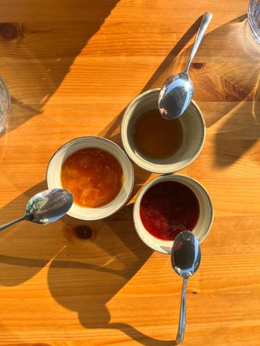 drie schalen saus op een houten tafel met lepels bij La Marelle in Corberon