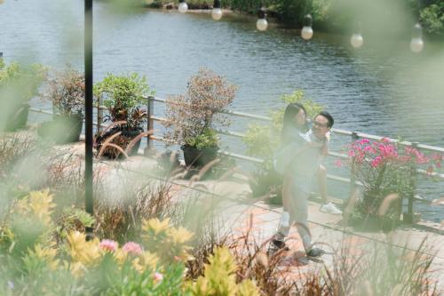 a man and a woman standing next to a body of water at USABAI Riverside Boutique Hotel in Chanthaburi