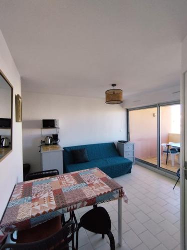 un salon avec un canapé bleu et une table dans l'établissement Near the port and the beach, à Frontignan