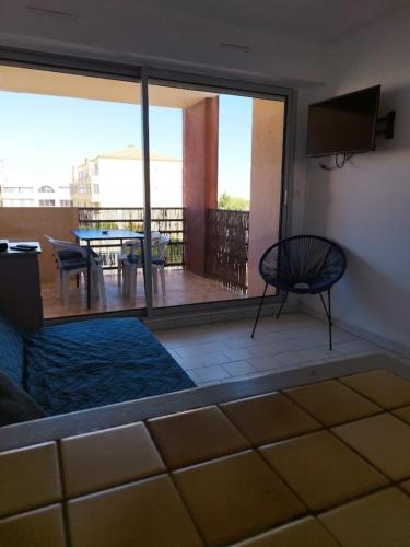 une chambre avec un balcon avec une table et une chaise dans l'établissement Near the port and the beach, à Frontignan