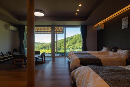 a hotel room with two beds and a large window at THE TANADA SAUNA サウナ 露天風呂 棚田一望 Refaシャワードライヤー in Sakai