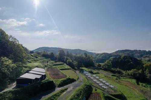 an aerial view of a farm with a barn and a field at THE TANADA SAUNA サウナ 露天風呂 棚田一望 Refaシャワードライヤー in Sakai