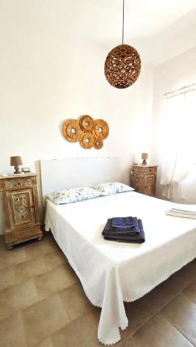 a bedroom with a large white bed and a chandelier at Casa del Pescatore in Nardò