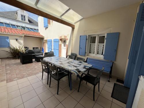 un patio avec une table, des chaises et un canapé dans l'établissement Villa de caractere 150m de la plage, à Saint-Gilles-Croix-de-Vie
