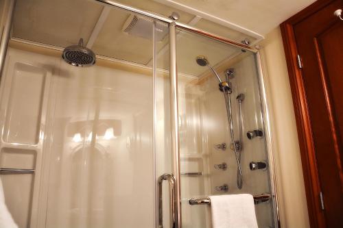 a shower with a glass door in a bathroom at Condos Memphrémagog in Magog-Orford
