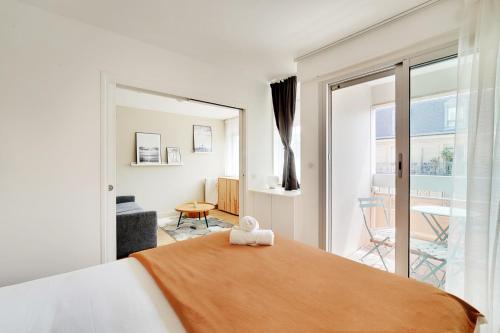 une chambre avec un grand lit et un balcon dans l'établissement Bel appartement design proche Gare de Lyon, balcon, à Paris