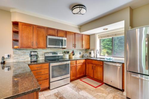 a kitchen with wooden cabinets and stainless steel appliances at 1 Mi to Loon Mountain Lincoln Haven with Balcony in Lincoln