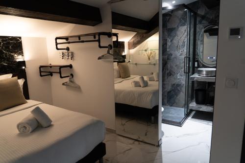 a room with two beds and a bathroom with a mirror at La Villa Ora in Antibes