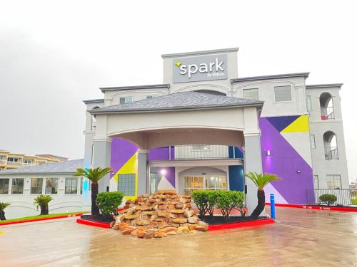 a building with a colorful front with a pile of logs at Spark By Hilton Galveston in Galveston