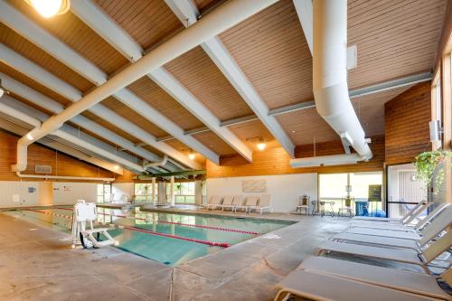 an indoor swimming pool with tables and chairs in a building at 1 Mi to Loon Mountain Lincoln Haven with Balcony in Lincoln