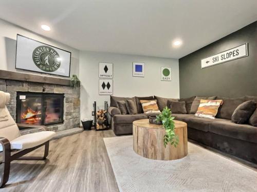 a living room with a couch and a fireplace at BeaverBox AC, Pool, Hot Tub, Sauna, Near Resort in Killington