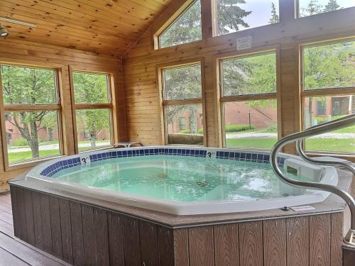 Cette chambre dispose de fenêtres et d'un grand bain à remous. dans l'établissement BeaverBox AC, Pool, Hot Tub, Sauna, Near Resort, à Killington